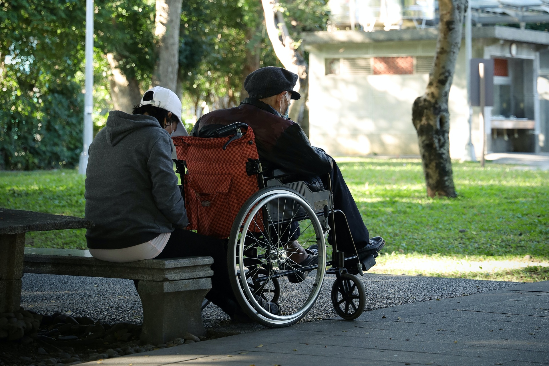 Starsza osoba na wózku wraz z opiekunem
