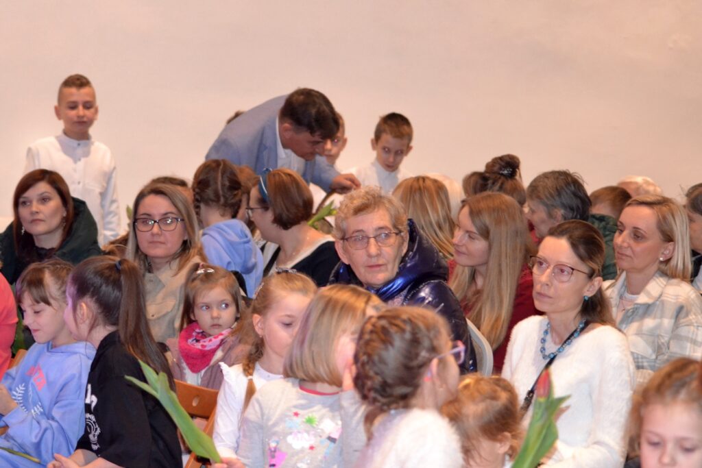 Dzień Kobiet, Szydłów, 8 marca 2023. Wiceprzewodniczący RM Zbigniew Głogowski rozdaje kwiaty Paniom.