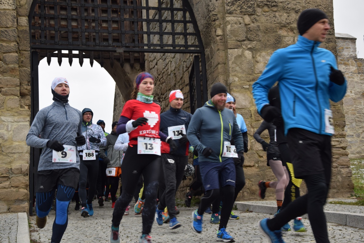 Biegacze biegną przez średniowieczną bramę w Szydłowie